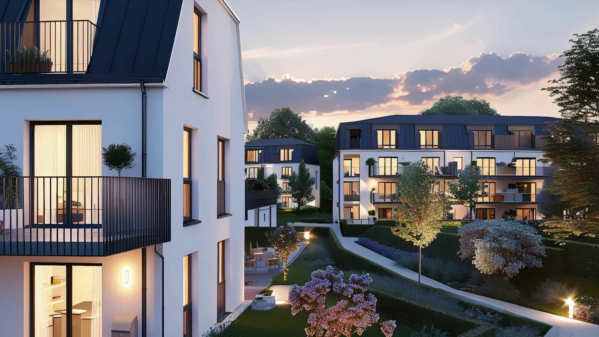 Beleuchtete moderne Wohnanlage mit Balkonen in der Abenddämmerung