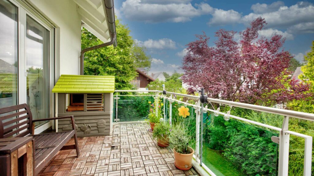 Covered terrace with a bench and a view of the greenery at a property in Munich-Forstenried