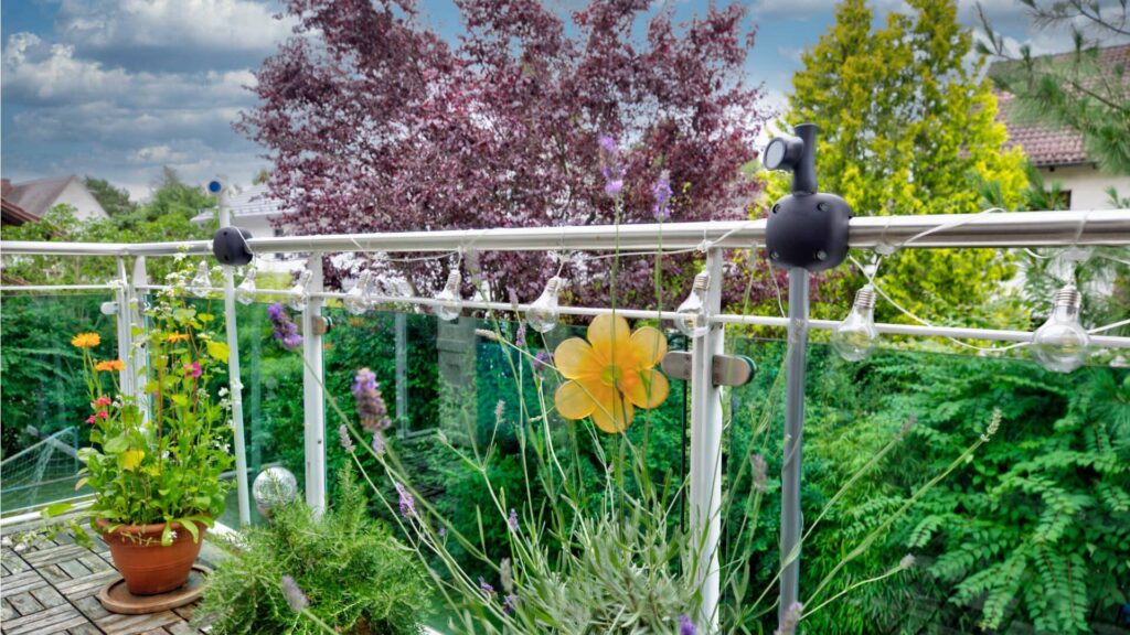 Balcony railing with flower pots and a view of a blossoming tree at a house in Munich-Forstenried