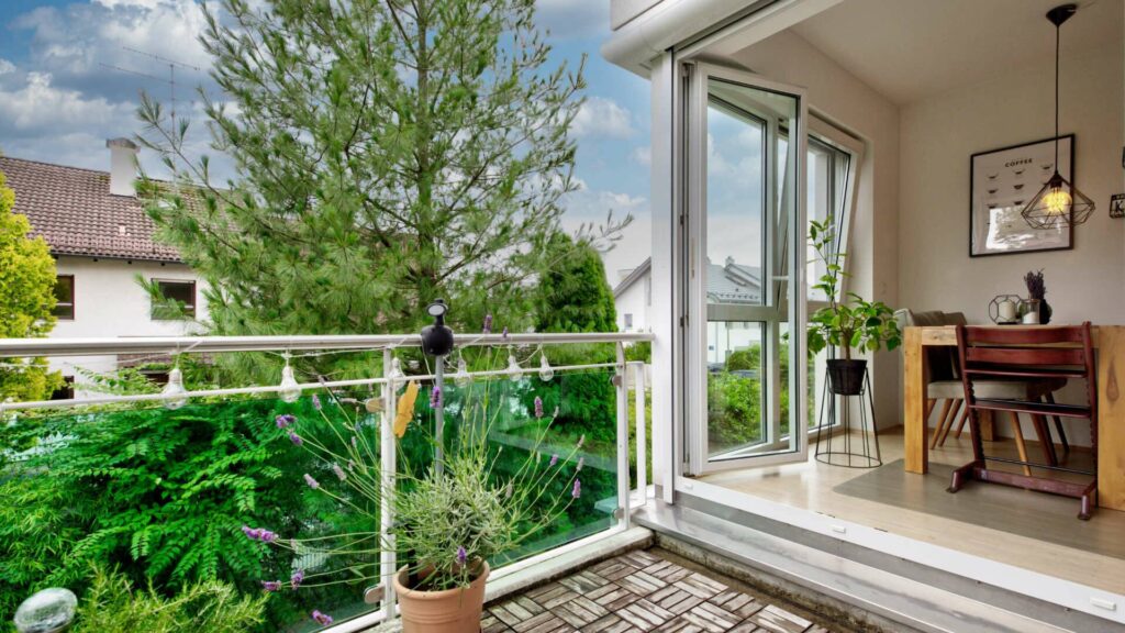 Terrace with plants and open balcony door to the living room in an apartment in Munich-Forstenried
