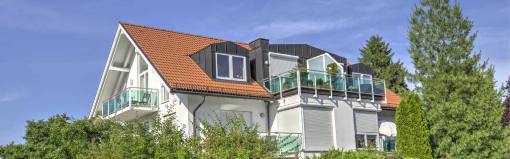 Panoramic view of an apartment building with balconies and gabled roof in Munich-Forstenried
