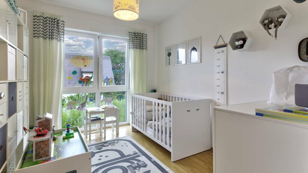 Bright nursery with a baby crib and window facing the garden in an apartment in Munich-Forstenried