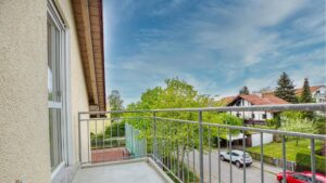 Balkon mit Metallgeländer und Blick auf Nachbarhäuser und Bäume in Germering.