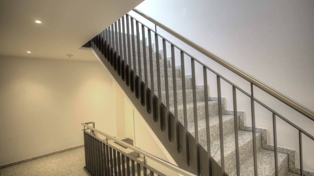 Modernes Treppenhaus mit schwarzem Geländer und hellen Wänden in einem Wohnhaus in Gröbenzell.