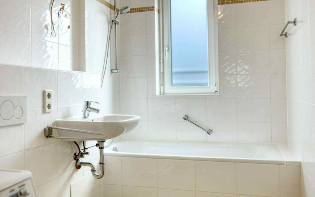Badezimmer der Großhadener Wohnung mit Wanne, Waschbecken und Fenster in Großansicht