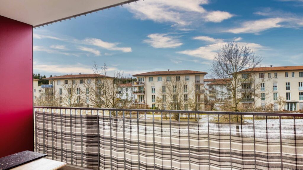 Balkon der Großhadener Wohnung mit Blick auf Nachbargebäude und winterliche Grünfläche