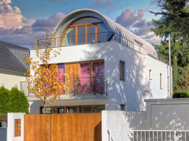 Architektonisch auffälliges Wohnhaus mit rundem Dach und farbigen Fensterscheiben in Aubing