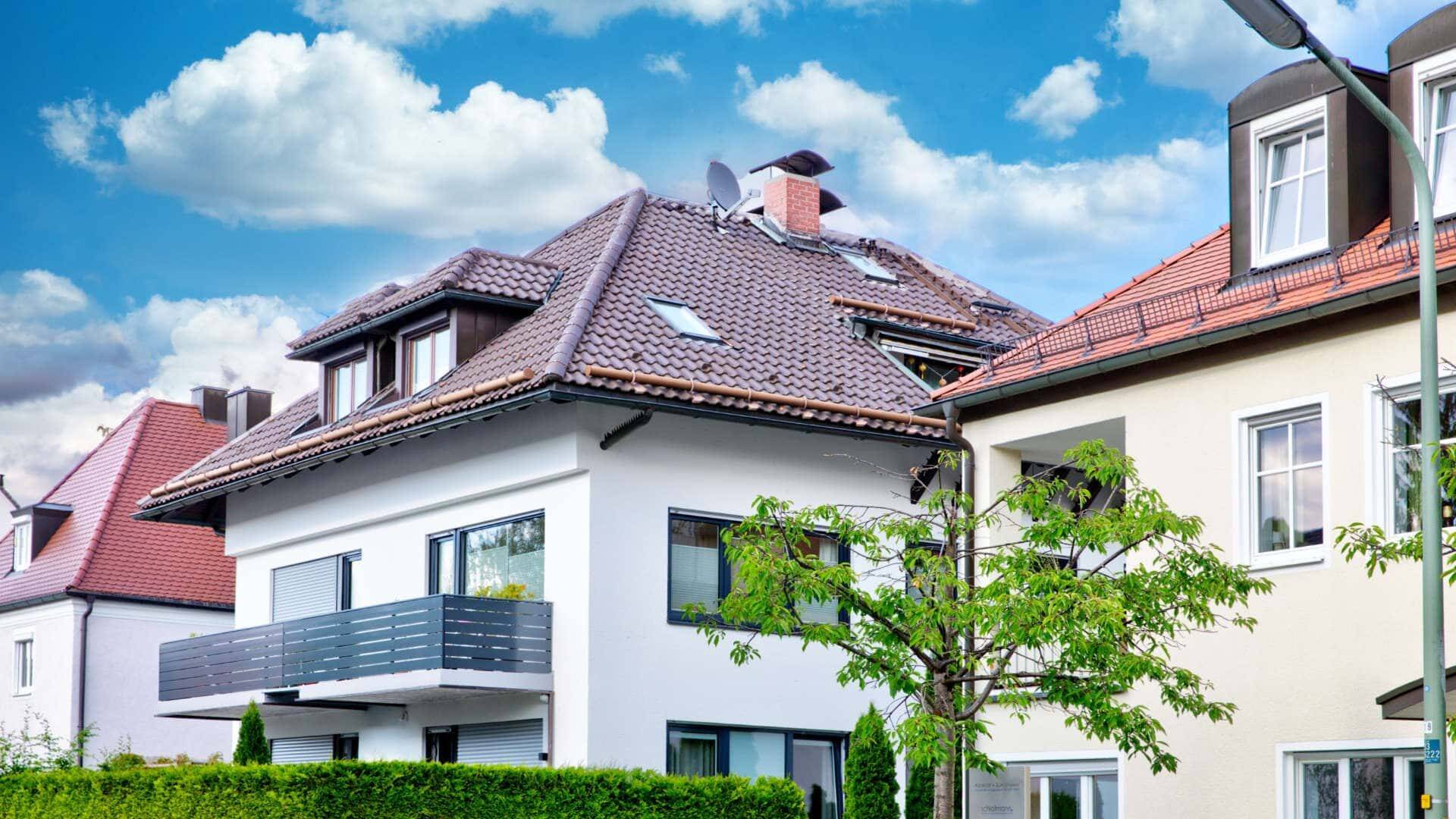 Wohnhäuser mit Balkon, Dachgauben und rotem Ziegeldach in München-Berg am Laim