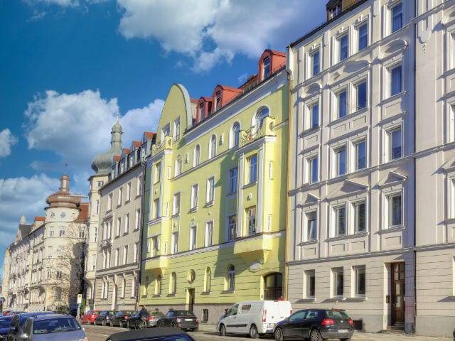 Gelbe und weiße historische Fassaden mit parkenden Autos in München-Haidhausen – Symbolbild zu Immobilienpreisen