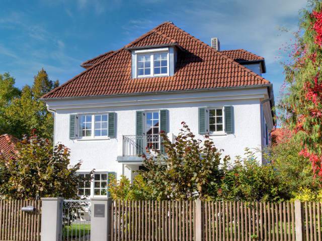 Klassisches weißes Wohnhaus mit Fensterläden und Dachgaube in München-Harlaching