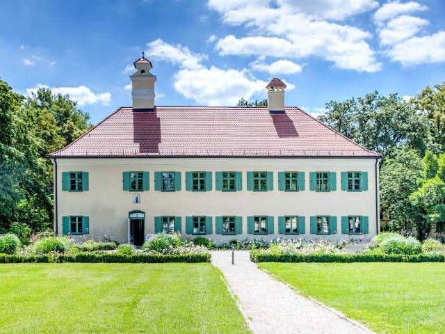 Herrschaftliches Landhaus mit grünen Fensterläden und gepflegter Grünanlage in München-Moosach
