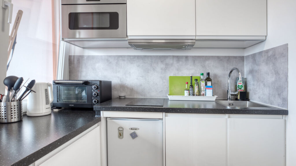 Compact built-in kitchen from the Laimer apartment with worktop, microwave and sink