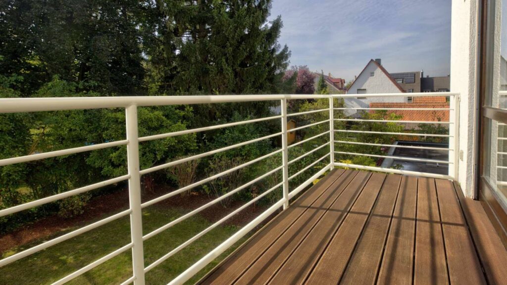 Balkon des Lerchenauer Hauses mit Holzdielen und Blick über Gärten und Nachbarhäuser