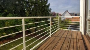 Balkon des Lerchenauer Hauses mit Holzdielen und Blick über Gärten und Nachbarhäuser