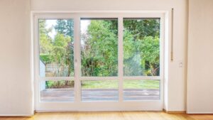 Leeres Wohnzimmer des Lerchenauer Hauses mit großer Terrassentür und Blick in den Garten