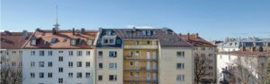 Blick über Dächer und Altbaufassaden benachbarter Häuser aus dem Fenster einer Dachgeschosswohnung in der Maxvorstadt München