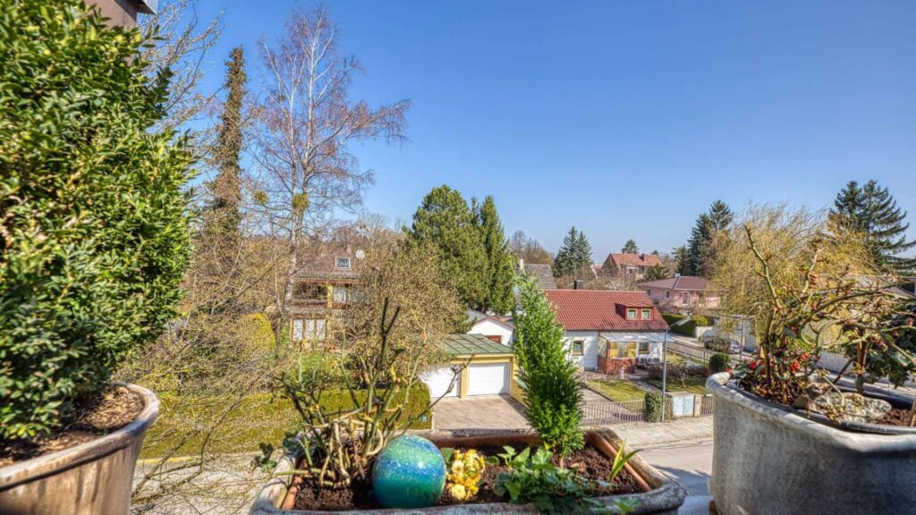 Blick von der Terrasse über Pflanzkübel auf Nachbarhäuser der Wohnung in München-Obermenzing