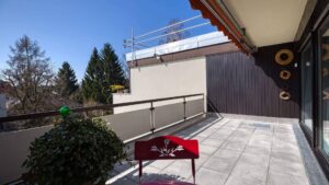 Paved roof terrace with bench and wood cladding of the apartment in Munich-Obermenzing
