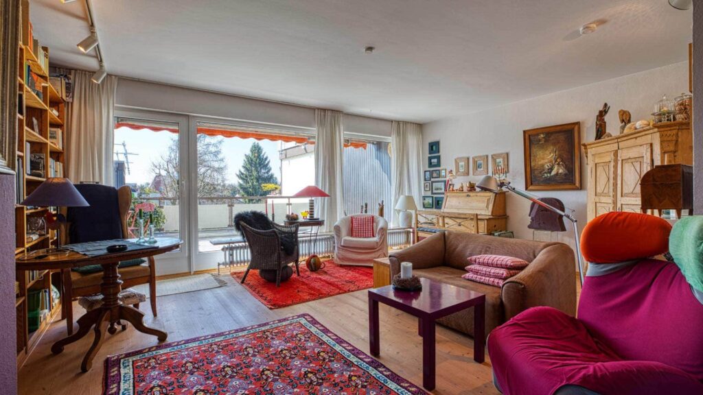 Bestehendes Wohnzimmer mit antiken Möbeln, Sesseln und Terrassentür in einer Wohnung in Obermenzing