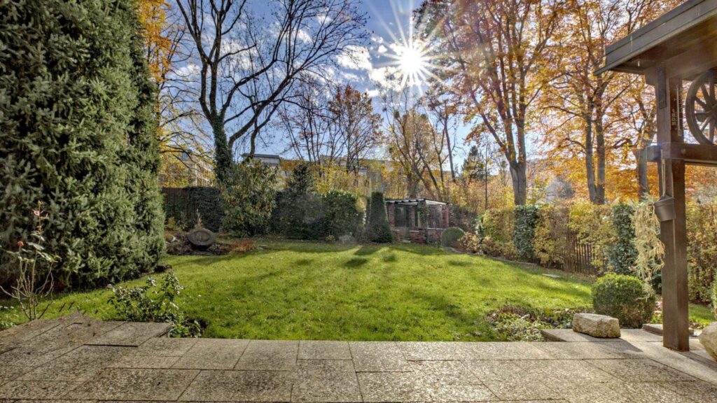 Sonnendurchfluteter Garten des Grundstücks in Obersendling mit Terrasse und altem Baumbestand