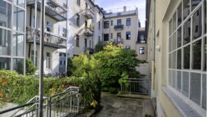 Greened courtyard with historic façades and balconies in the backyard of the property on Orleansplatz in Munich