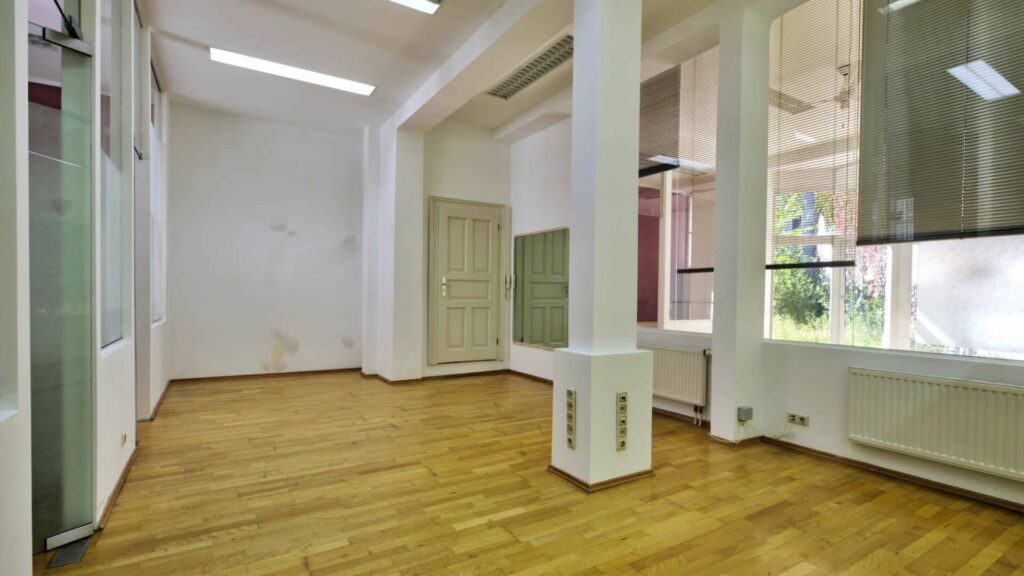 Empty old building with a pillar, high windows and wooden floor in a commercial unit on Orleansplatz, Munich