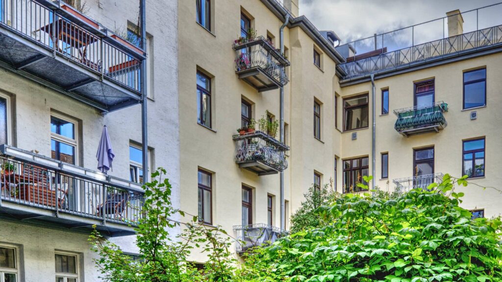 Old building facade with balconies and ornamental plants at Ostbahnhof in Munich, view from an inner courtyard