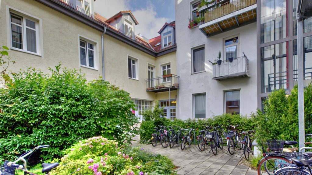 Inner courtyard with balconies, bicycles and flowering plants in a residential building at Ostbahnhof in Munich