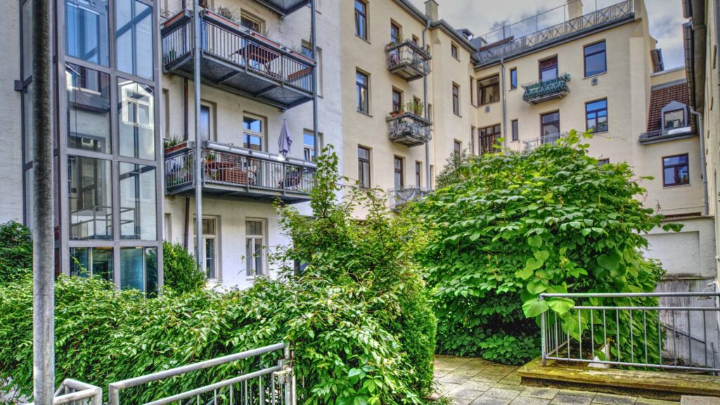 Inner courtyard with balconies, glass construction and dense greenery in a residential building on Ostbahnhof in Munich