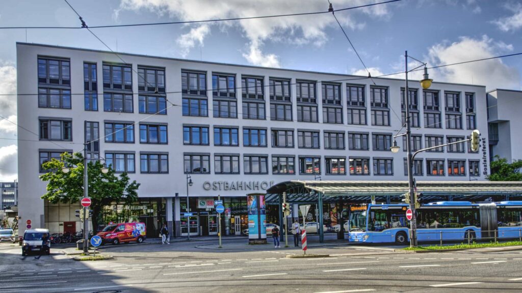 Multistory building with shops on the ground floor and a tram at the Ostbahnhof in Munich
