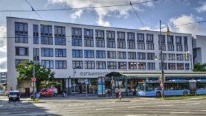 Multistory building with shops on the ground floor and a tram at the Ostbahnhof in Munich