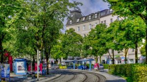Street scene with a tram and trees in front of a building at Ostbahnhof in Munich