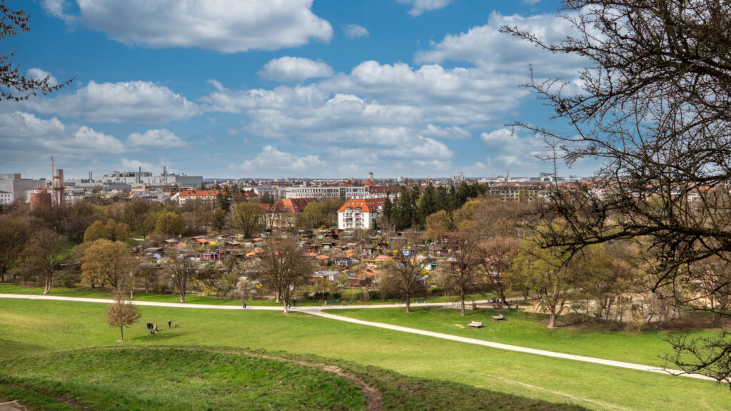 Panoramic view over green spaces in the English Garden with the Munich city skyline in the background