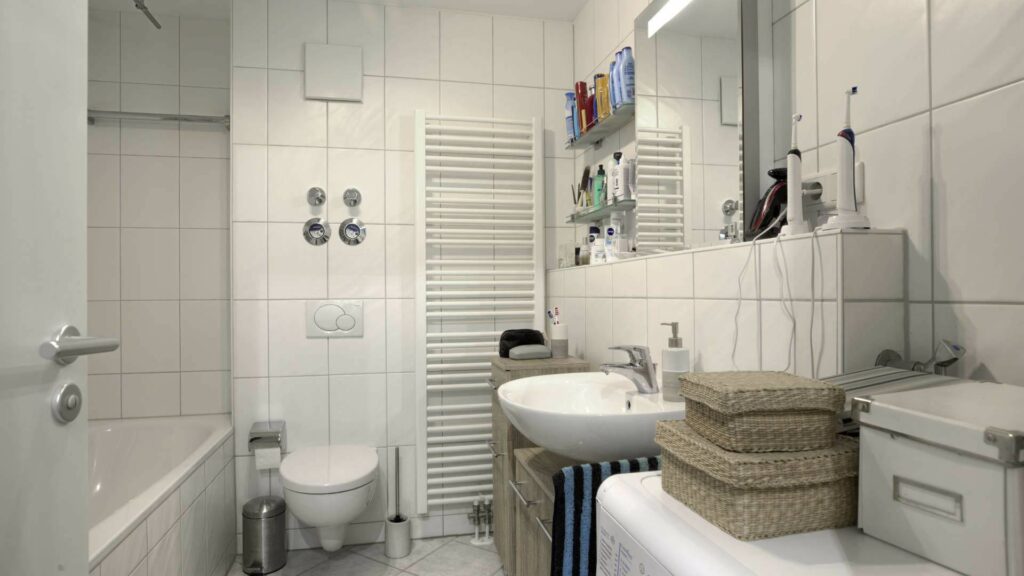 Badezimmer mit Waschbecken, Badewanne und Handtuchheizkörper in einer Wohnung in München-Sendling