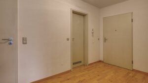 Helle Diele mit Parkettboden und zwei Zimmertüren in einer Dachgeschosswohnung in München-Thalkirchen