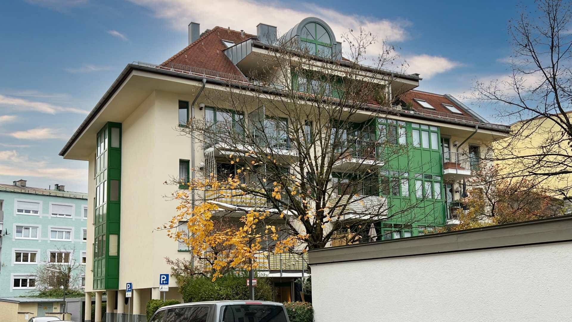 Mehrstöckiges Wohnhaus mit grüner Fassadengestaltung und Balkonen in München-Thalkirchen.