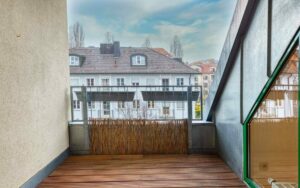 Holzterrasse mit Sichtschutz und Blick auf Nachbarhäuser bei der Dachgeschosswohnung in Thalkirchen.