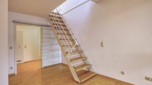 Ausklappbare Steiltreppe mit Geländer zum Dachgeschoss in einer Wohnung in München-Thalkirchen