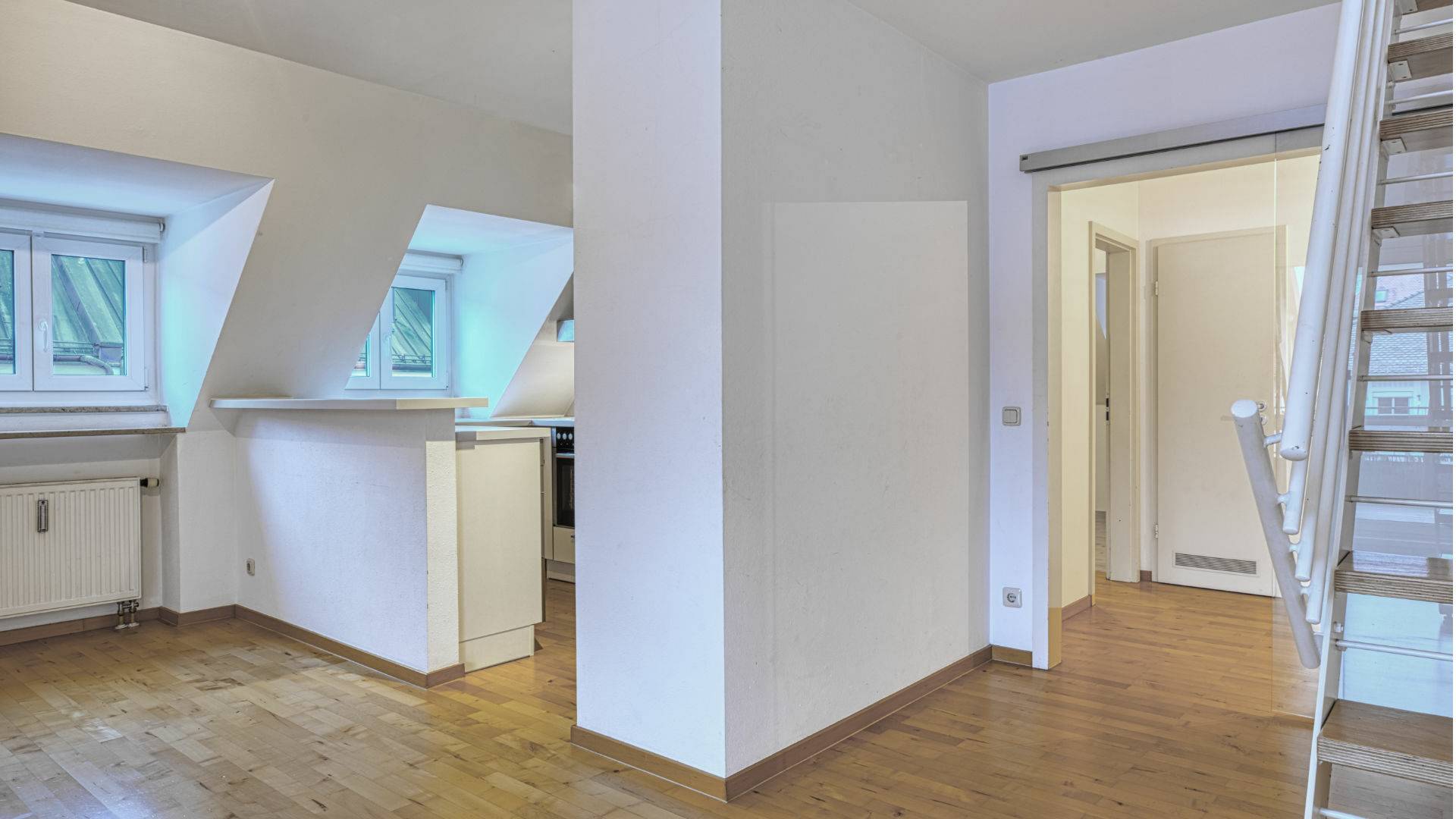 Offener Wohnbereich mit Dachfenstern, Parkett und Blick zur Galerietreppe in einer Wohnung in Thalkirchen.