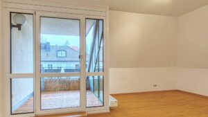 Leeres Wohnzimmer mit Parkettboden und Zugang zur Dachterrasse mit Blick über die Dächer in Thalkirchen.