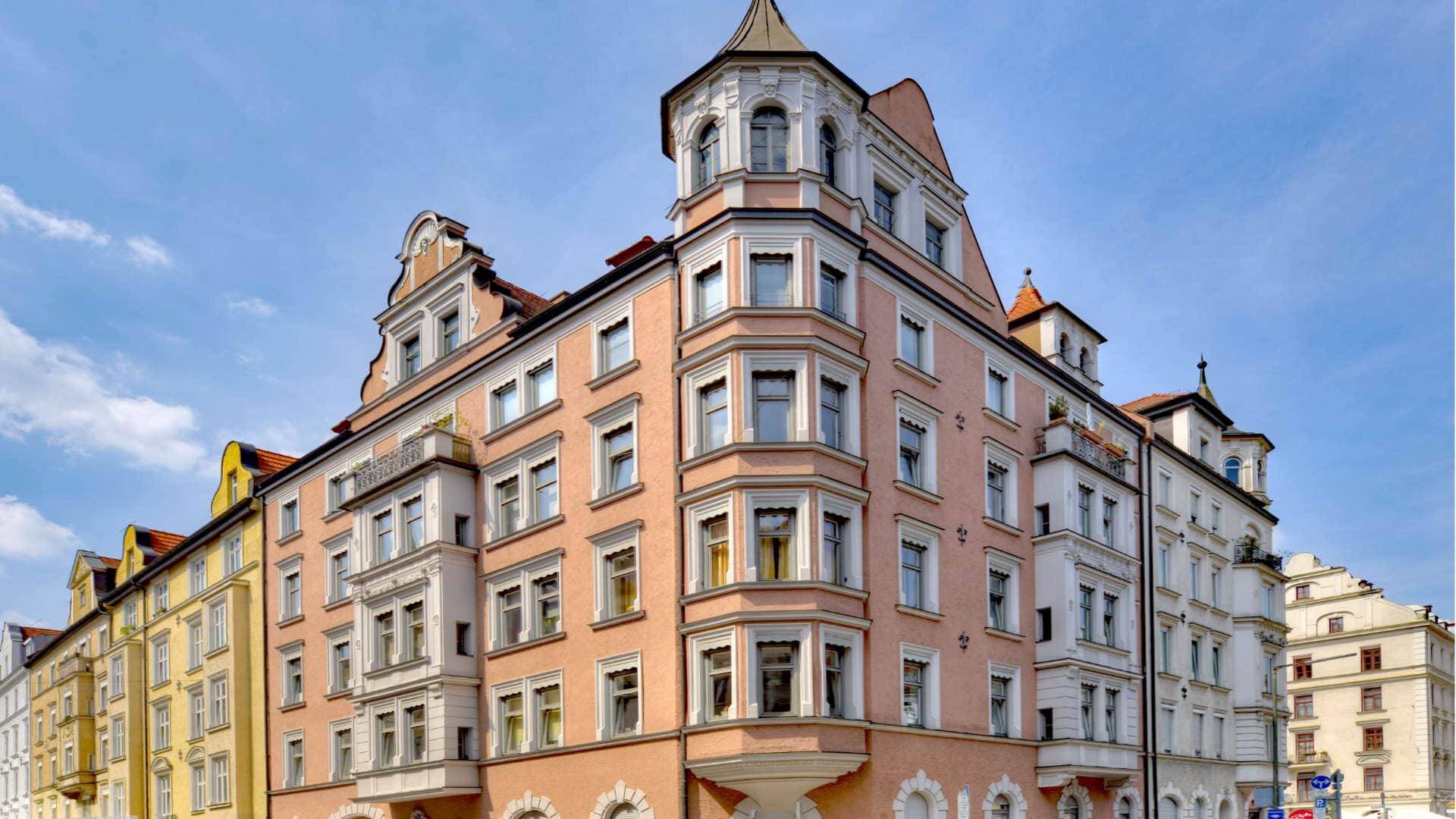 Historische Altbaufassade mit Erkertürmen in Rosa und Weiß in München