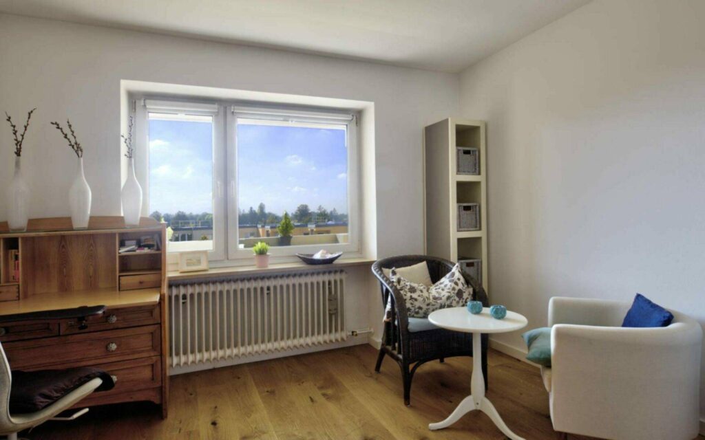 Inhabited study with desk, armchair, and large window with a wide view in Untermenzing.