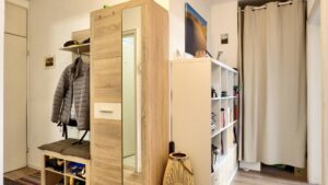 Hallway with wardrobe and mirrored cabinet of a 2-room apartment in Munich