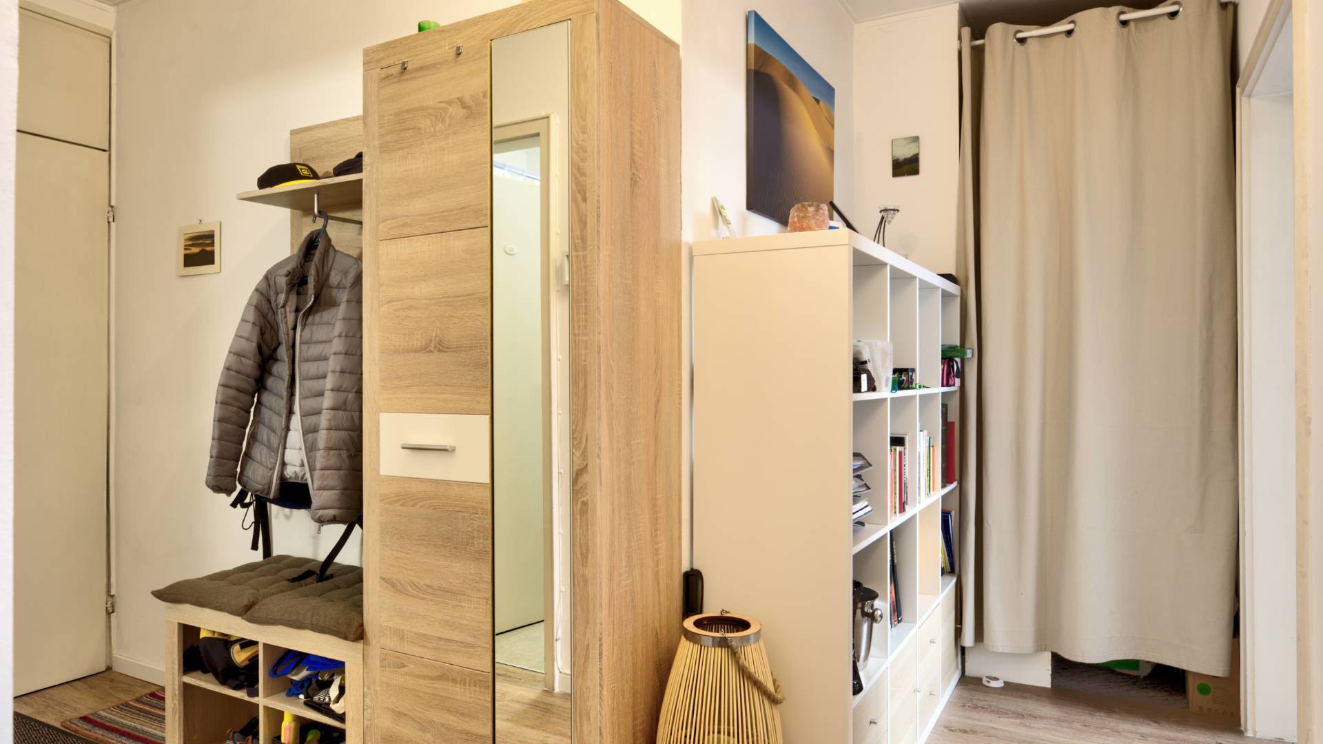 Hallway with wardrobe and mirrored cabinet of a 2-room apartment in Munich