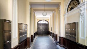 Representative entrance of the old building apartment in the Au district with historic mailboxes and stucco ceiling