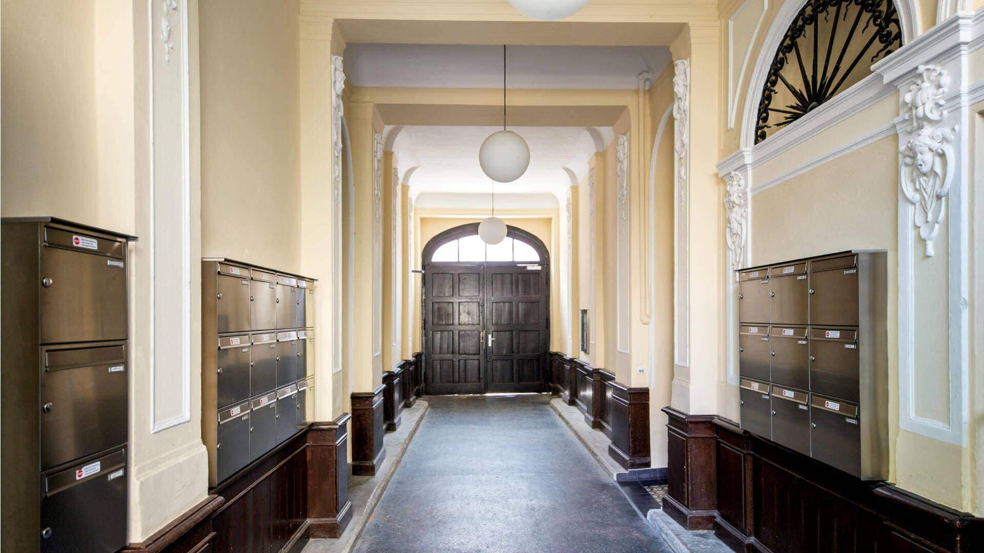 Representative entrance of the old building apartment in the Au district with historic mailboxes and stucco ceiling