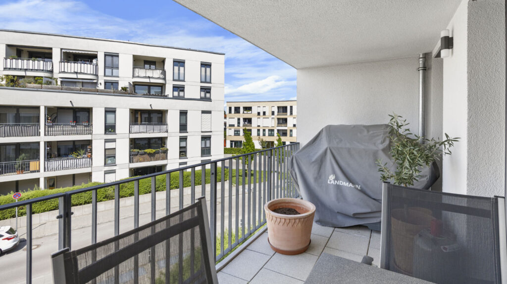Balcony with planter and privacy screen, view of a modern residential complex in Aubing