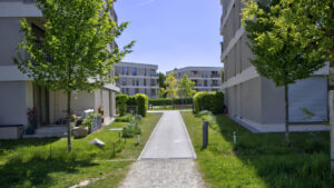 Aubing residential complex with path between the houses, private terrace, and seating area in the inner courtyard