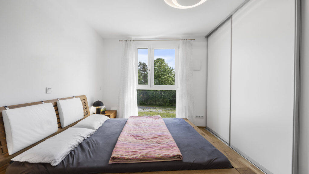Bedroom with a floor bed and built-in wardrobe in a condominium in Munich-Aubing