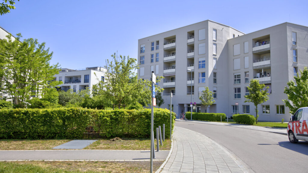 Modern residential complex with hedges and access road near an apartment in Munich-Aubing